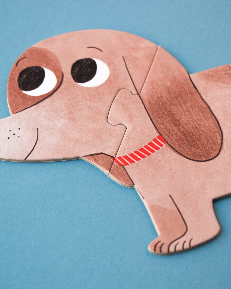 Dog-shaped paper puzzle on a blue background