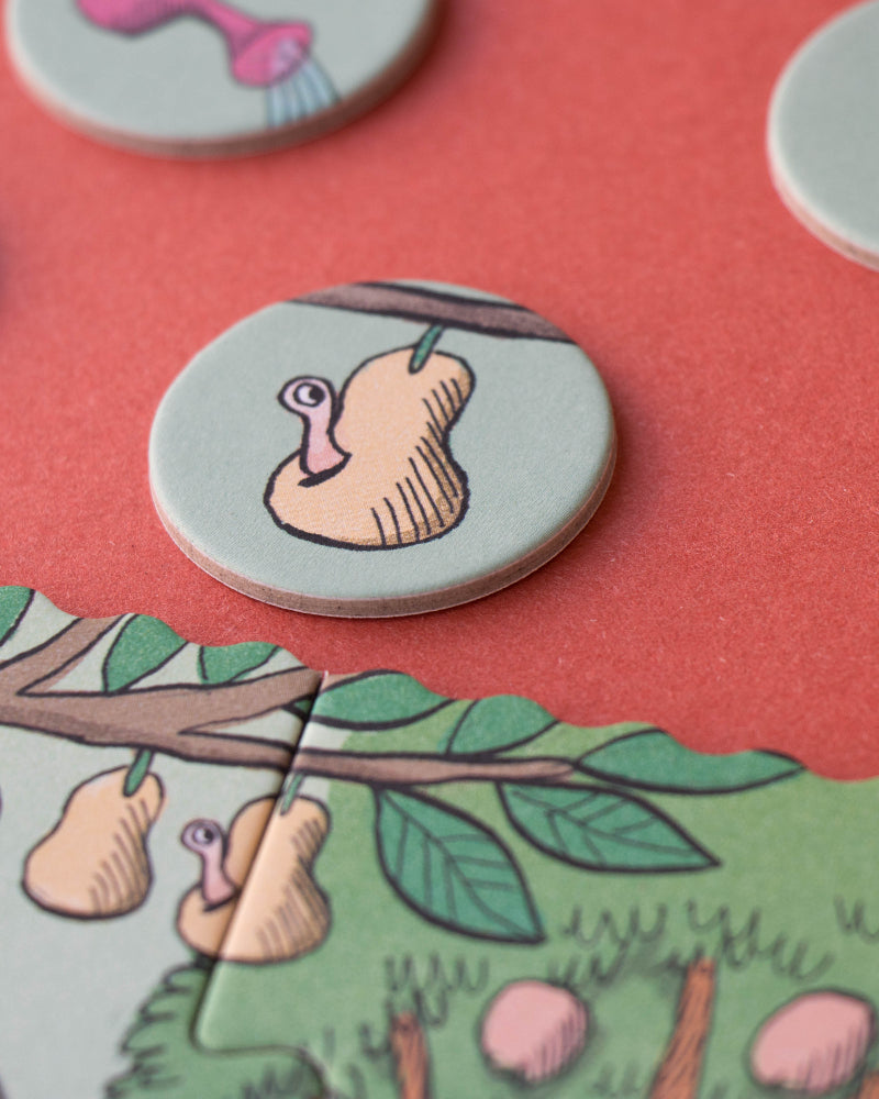 Round game pieces with cartoonish illustrations on a pink background