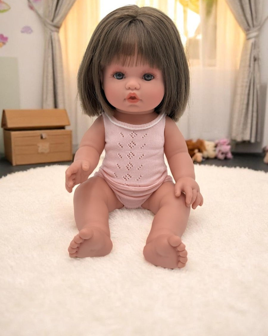 Milan realistic baby doll with straight brunette hair in pink pajamas for toddlers developmental play