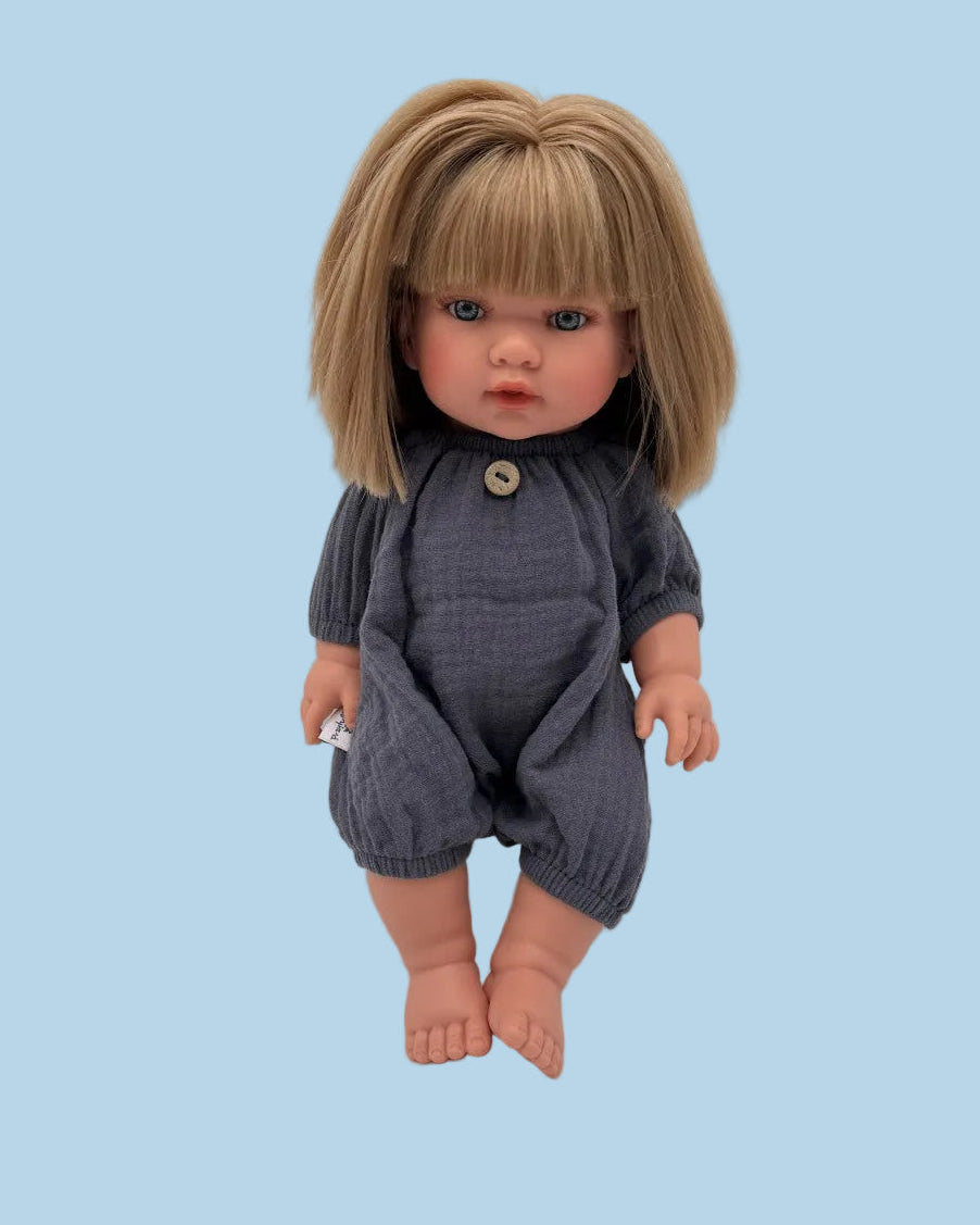Bebenita doll wearing handmade navy muslin romper with decorative button neckline, seated on white background
