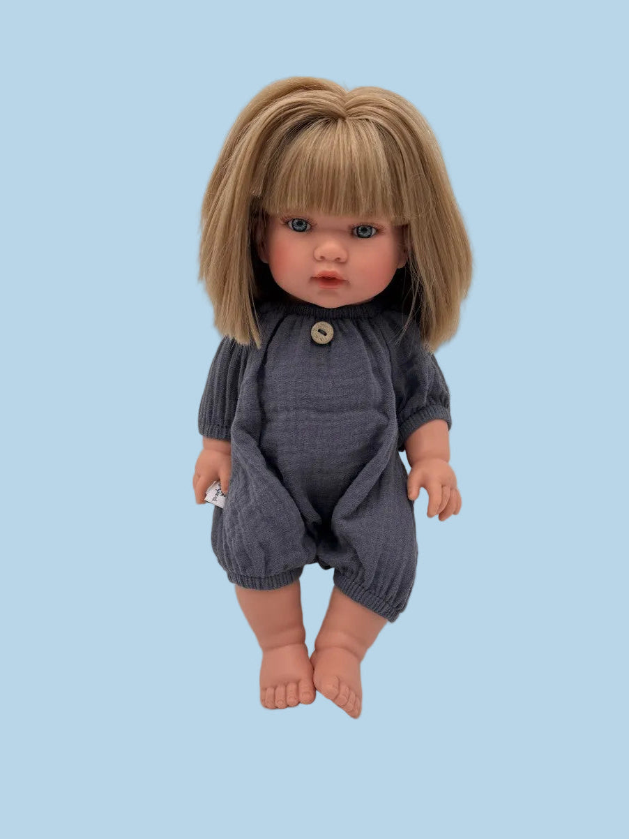 Bebenita doll wearing handmade navy muslin romper with decorative button neckline, seated on white background