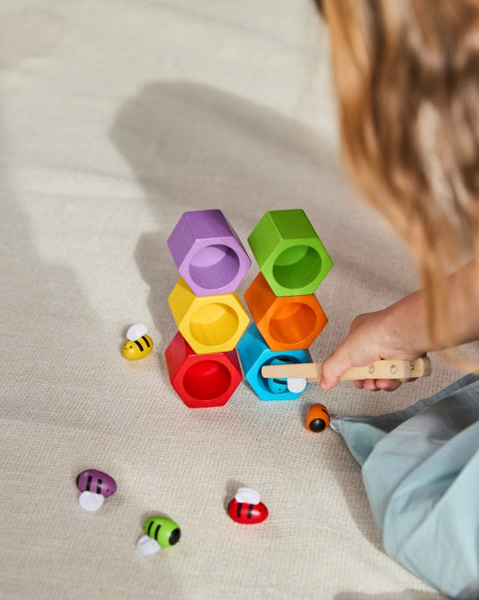 Child playing with colorful building blocks on a light surface