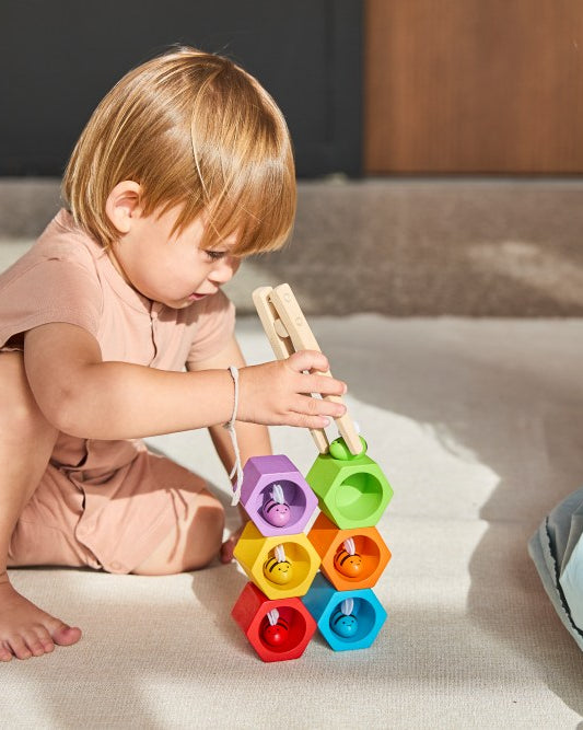 Two children playing with colorful building blocks on a bed.