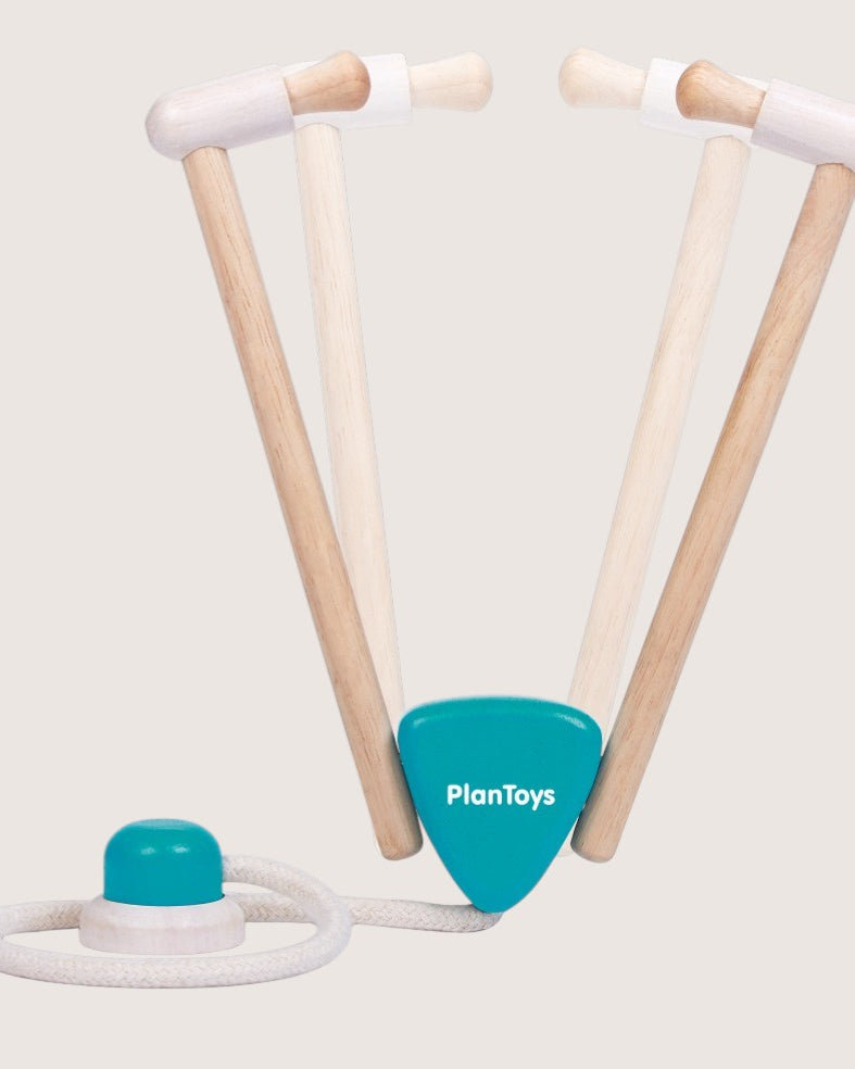 Wooden toy with a blue handle and white rope on a light gray background, featuring the PlanToys logo.