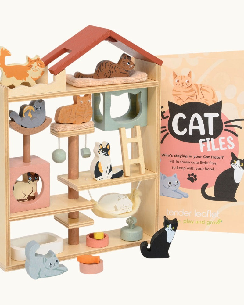 Wooden cat toy house with small cat figures and a 'Cat Files' book on a white background