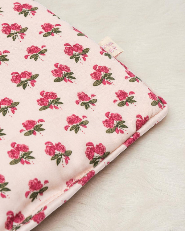 Close-up of Rosie Rose print fabric showing delicate pink roses with green leaves pattern and premium cotton texture with branded label