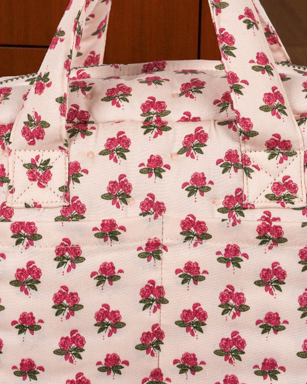 Close-up of Rosie Rose print fabric showing delicate pink roses with green leaves pattern and premium cotton texture