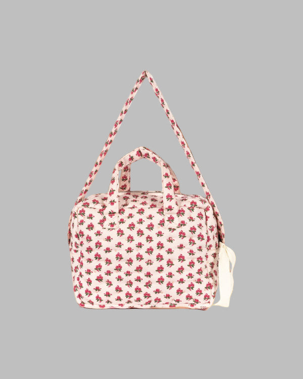 Side profile of vintage rose diaper bag displaying adjustable shoulder strap and compact carrying design