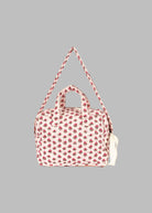 Side profile of vintage rose diaper bag displaying adjustable shoulder strap and compact carrying design