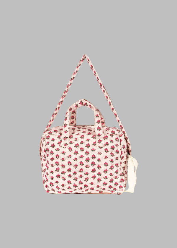 Side profile of vintage rose diaper bag displaying adjustable shoulder strap and compact carrying design