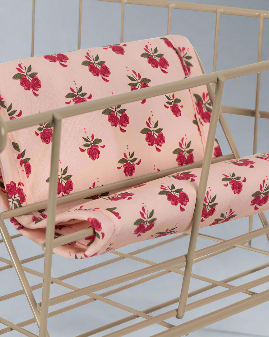 Close-up of Rosie Rose vintage print fabric featuring pink roses with green leaves on blush background with decorative tie closures