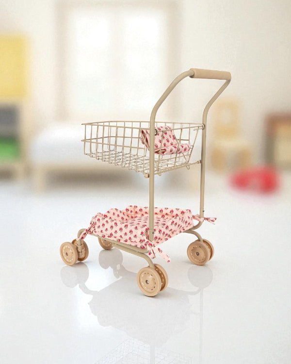 Small toy shopping cart with pink accents on a white surface
