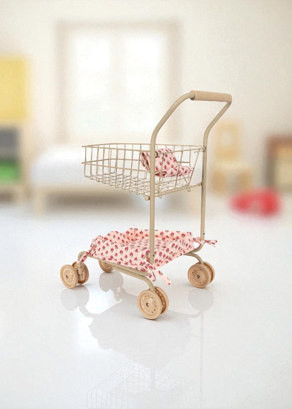 Small toy shopping cart with pink accents on a white surface
