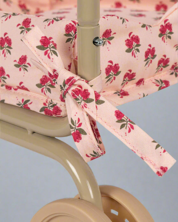 Premium fabric seat showing branded label accent and rose pattern detail on champagne wire basket frame