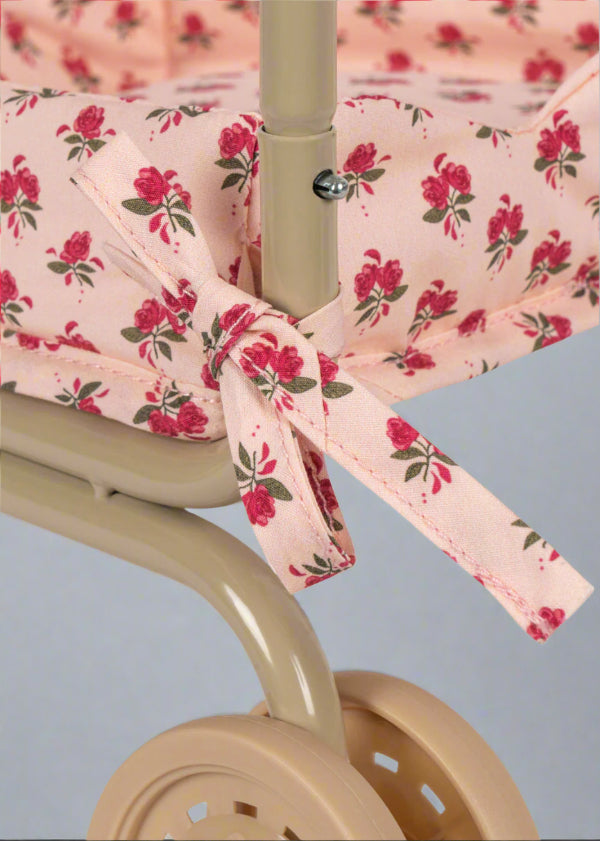 Premium fabric seat showing branded label accent and rose pattern detail on champagne wire basket frame