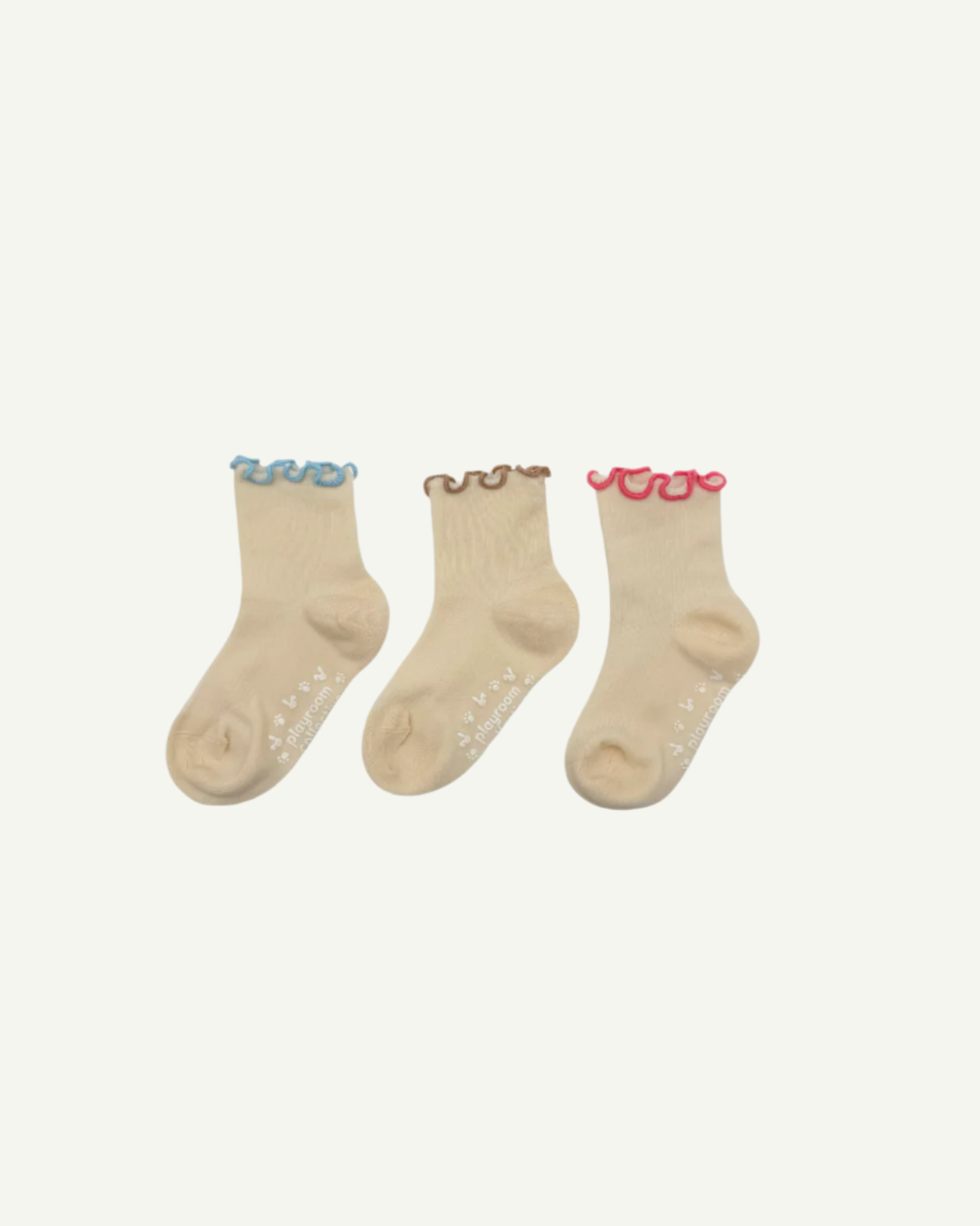 Three colorways of toddler ruffle socks: petal pink, skydream blue, and oat beige