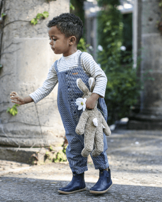 Toddler carrying large Senger beige rabbit companion showing attachment bond