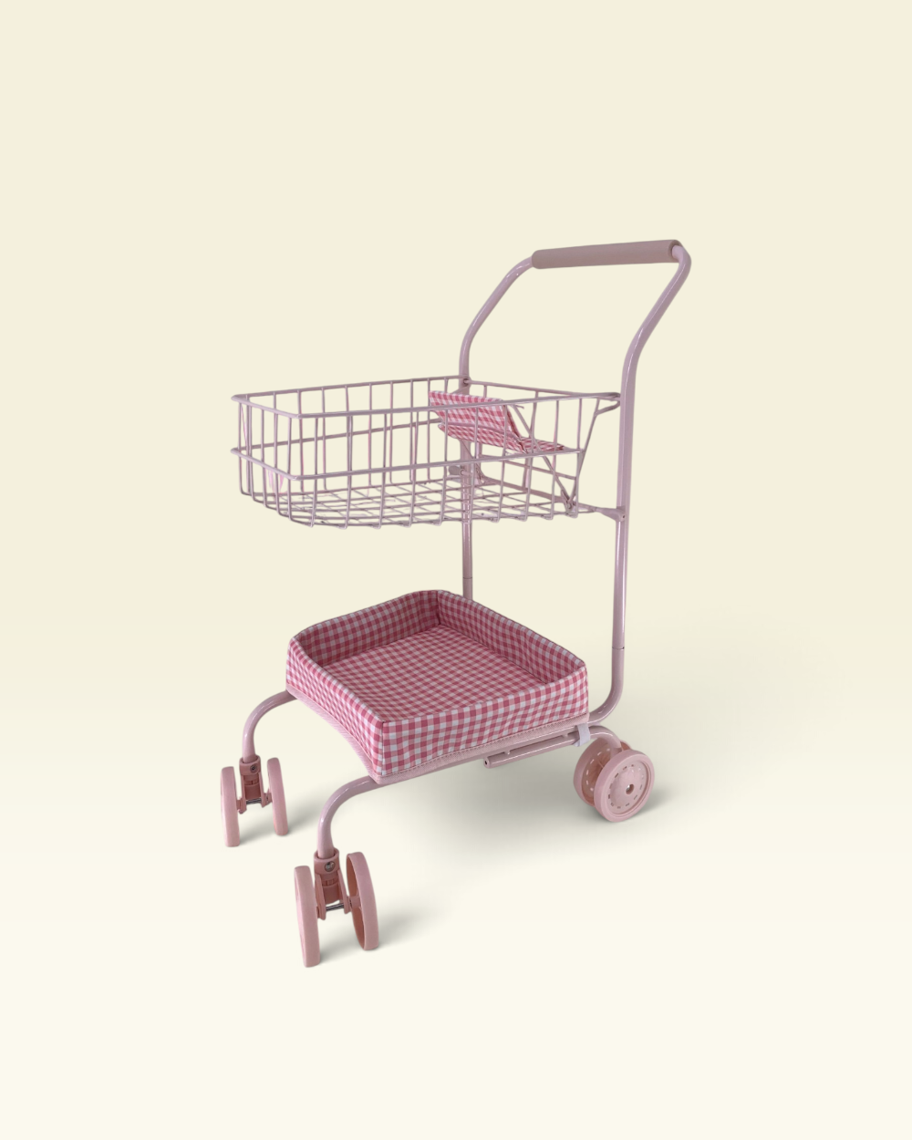 A pink metal shopping cart with a wire basket on top and a cushioned seat, shown on a plain cream background.