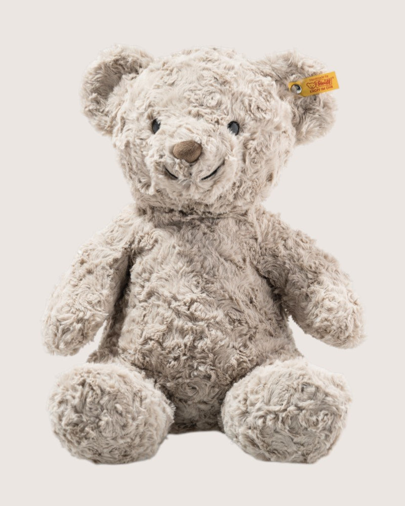 Plush teddy bear with a visible brand tag on a light background