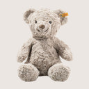 Plush teddy bear with a visible brand tag on a light background