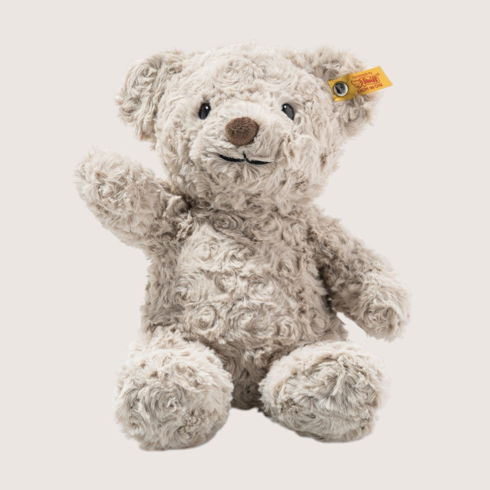 Plush teddy bear with a yellow tag on a light background