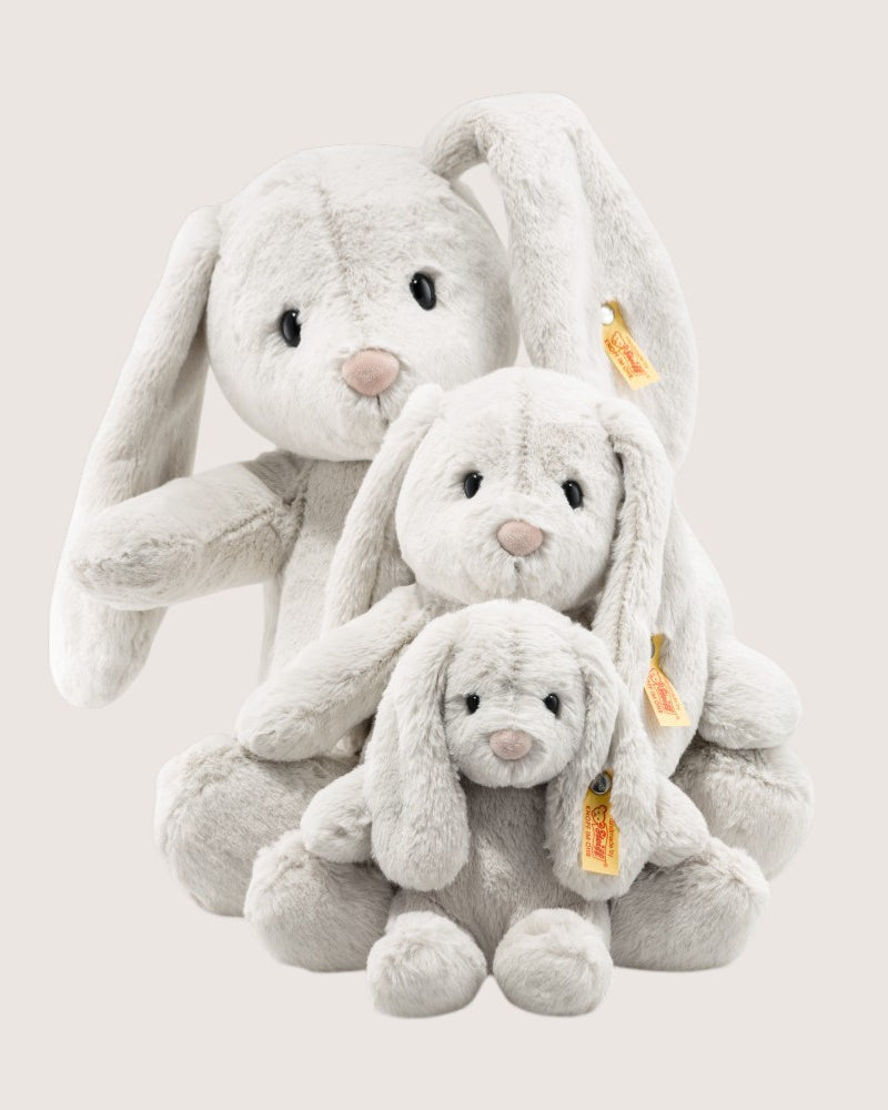 Three plush bunny toys of different sizes on a light gray background