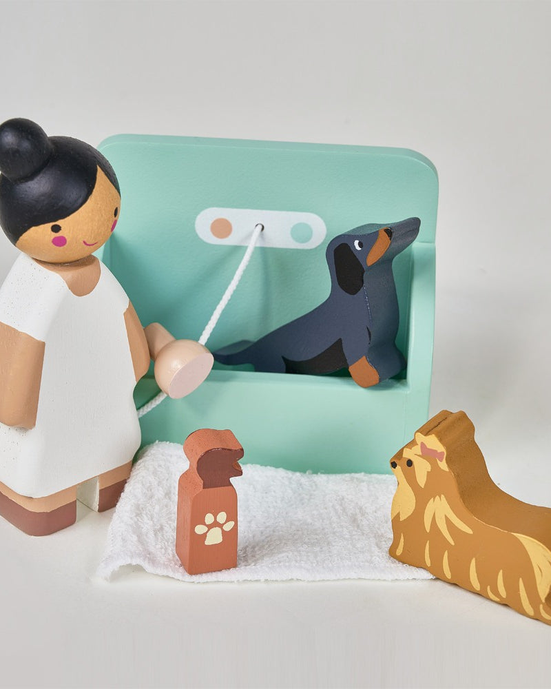 Wooden toy set with a girl, dog, and accessories on a light gray background