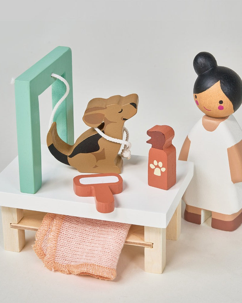 Wooden toy set with a dog, vet, and medical tools on a white surface