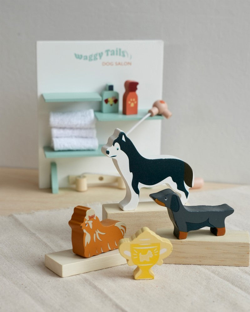 Set of wooden animal toys on a neutral background with a small shelf in the background.