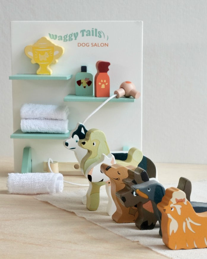 Wooden dog toys with a 'Waggy Tails Dog Salon' sign in the background.
