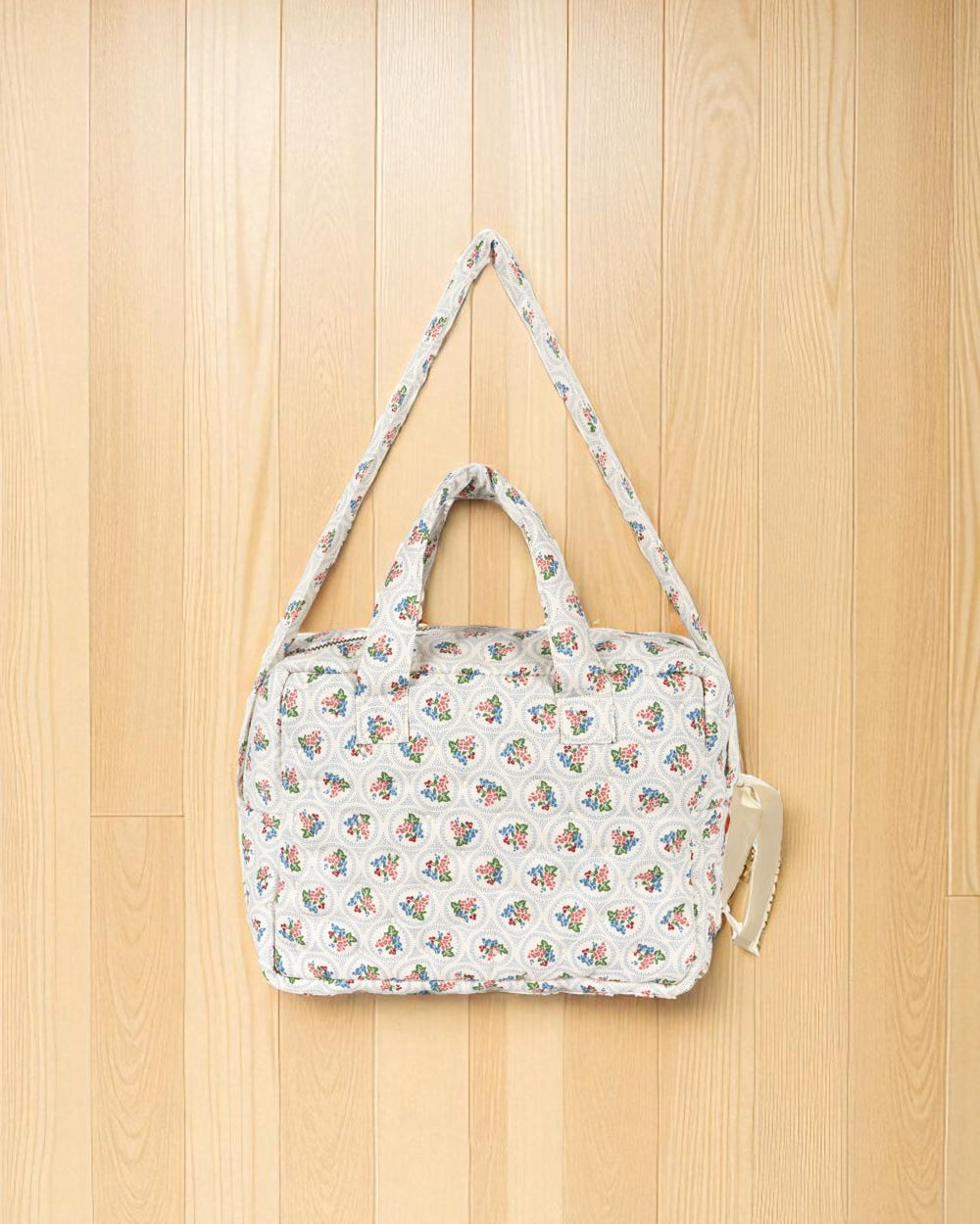 Doll diaper bag showing dual padded handles and adjustable crossbody strap for pretend play