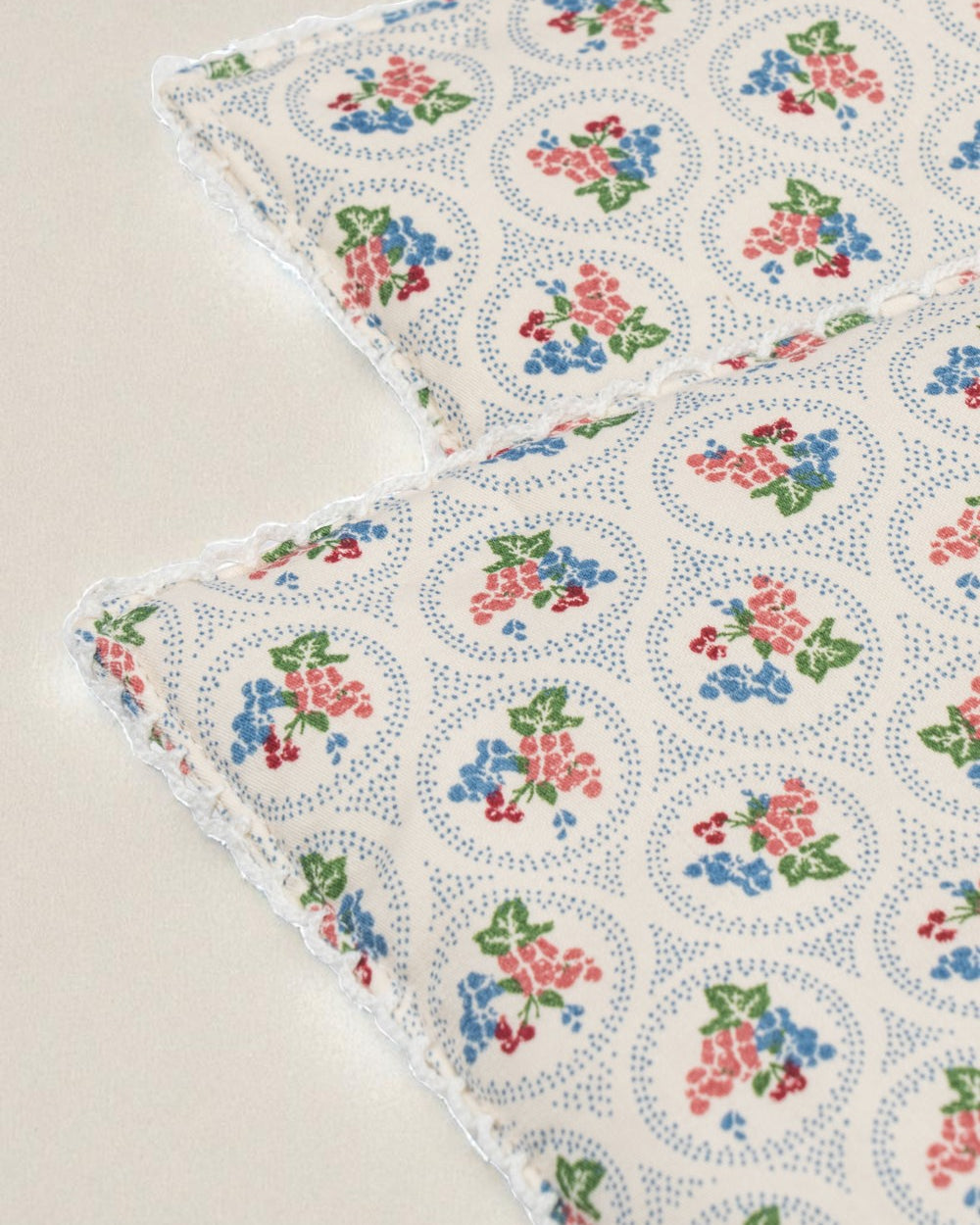 Close-up of Verona Blues print showing cornflower blue flowers with coral, cherry and green accents and dotted circle details