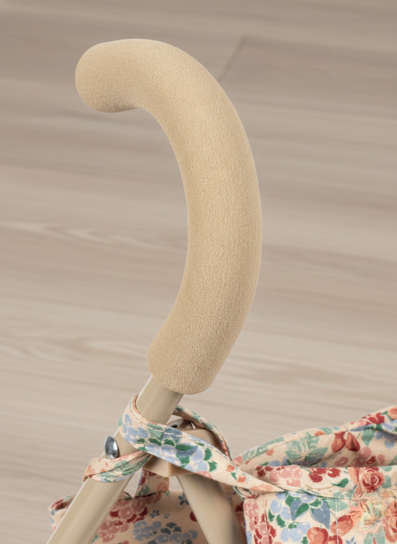Beige stroller handle with floral fabric on a beige background