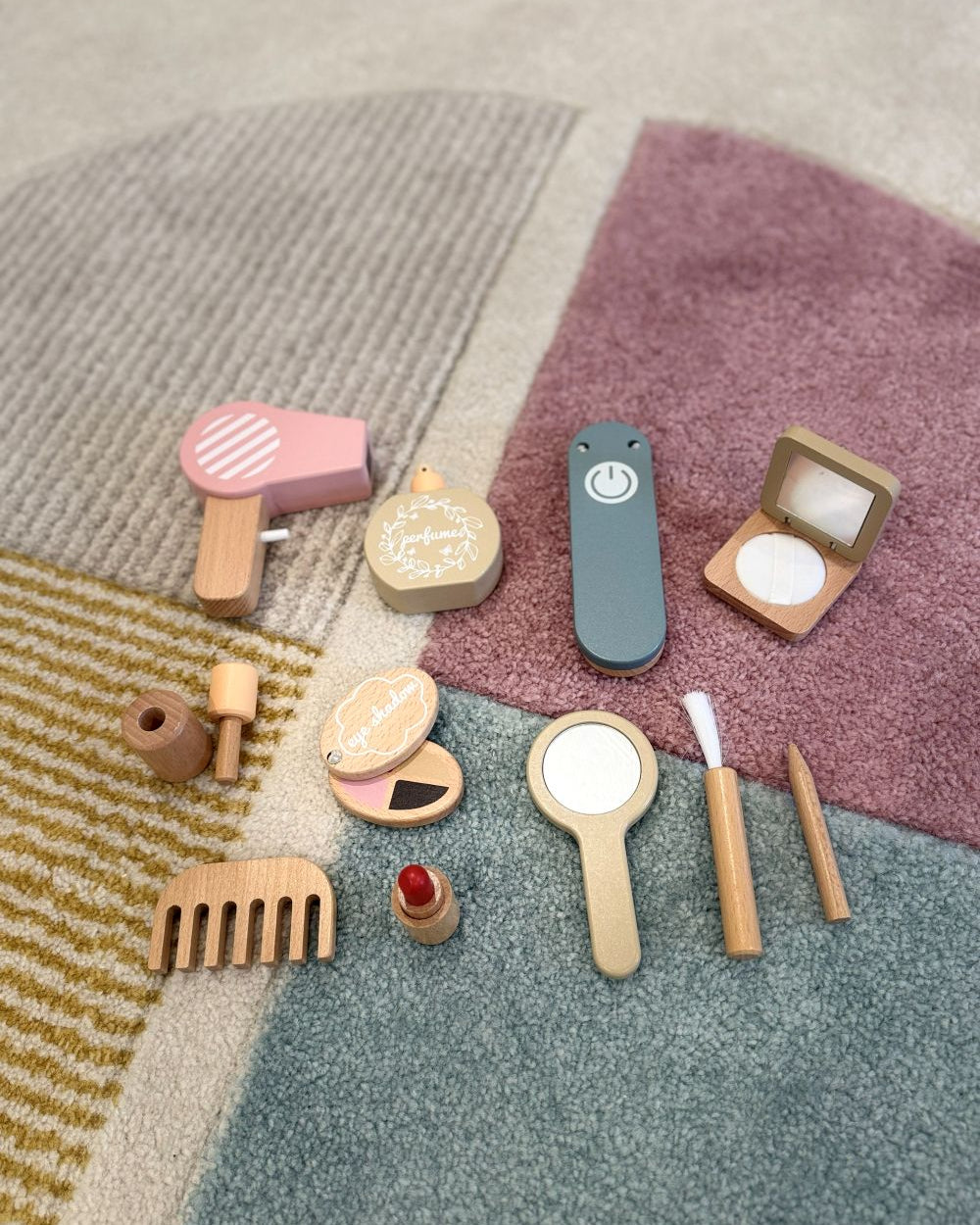Set of wooden toy makeup items on a textured surface
