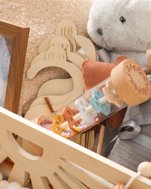Natural beechwood end cap detail of Montessori rain sound toy featuring engraved leaf pattern