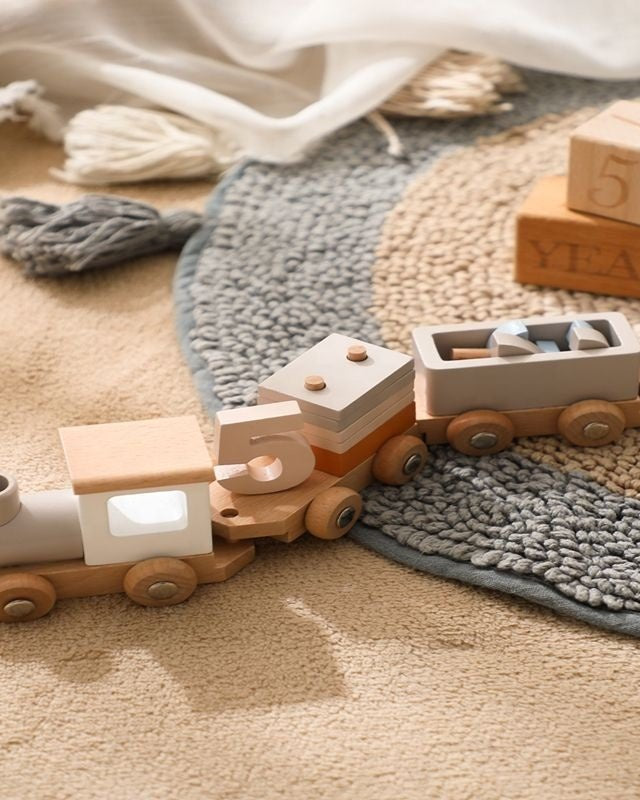 Handcrafted wooden Montessori train set with four connecting cars in natural wood and pastel colors