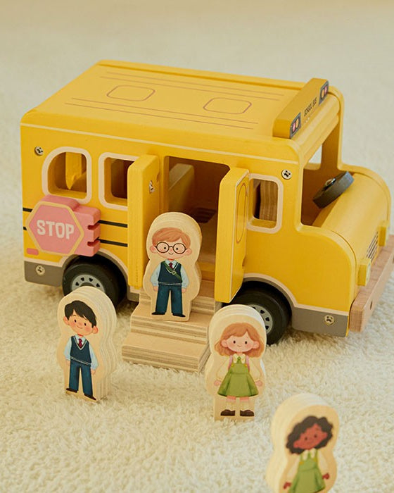 Complete 7-piece wooden school bus set showing bus, driver, four student figures, and wooden step piece