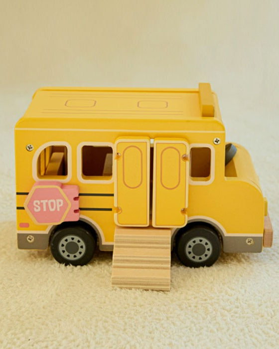 Close-up detail of smooth rounded wood edges and hand-painted pink stop sign on yellow school bus
