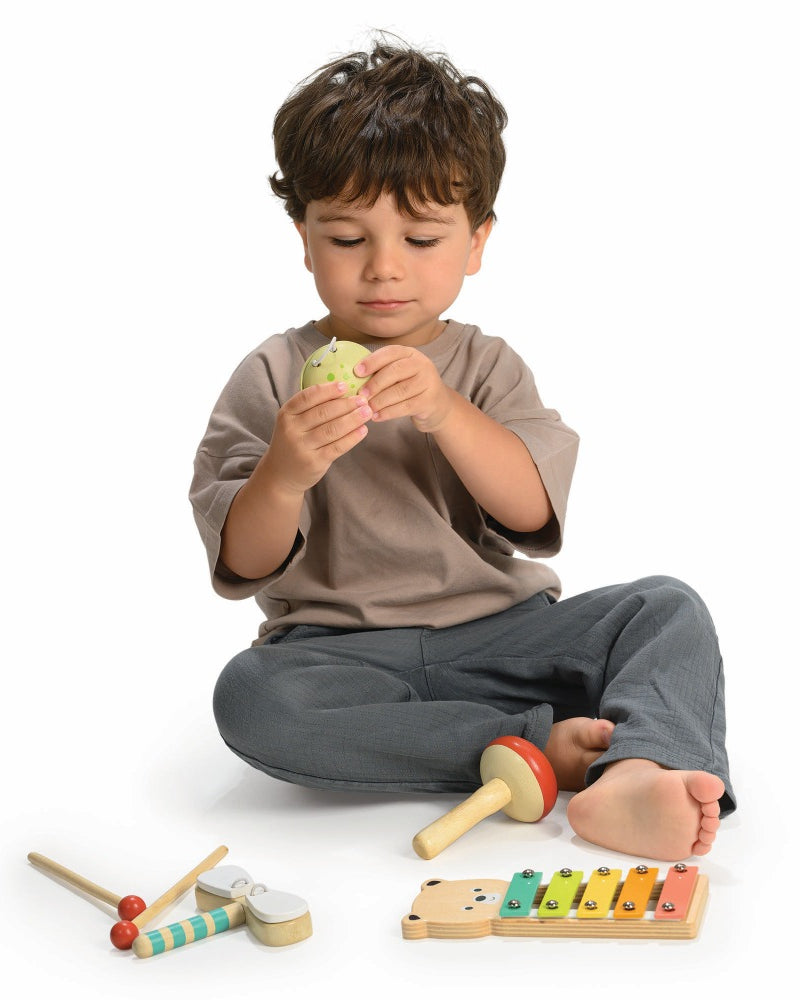 Child playing with Mentari bear xylophone and woodland percussion instruments