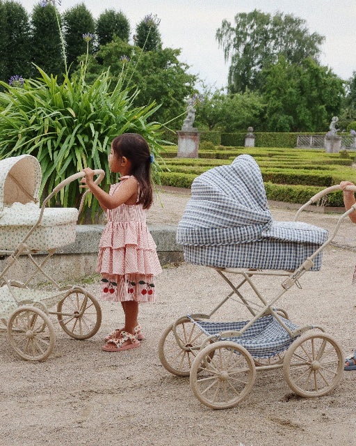 Charming cream and floral pattern doll pram with four spoked wheels and romantic quilted fabric details