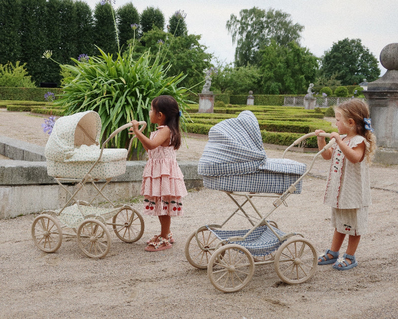 Charming cream and floral pattern doll pram with four spoked wheels and romantic quilted fabric details