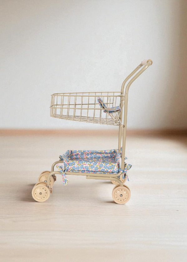 Side profile of premium toy shopping cart showing two-tier design with upper wire basket and lower padded seat platform