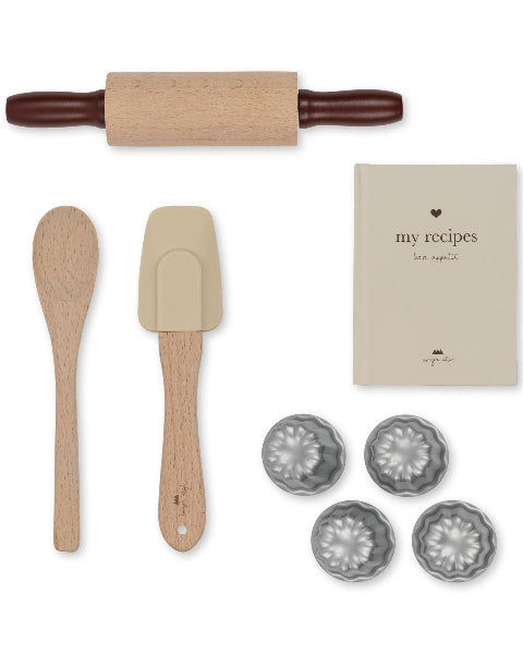 Child-sized baking equipment with rolling pin, mixing spoons and my recipes book perfect for little chefs