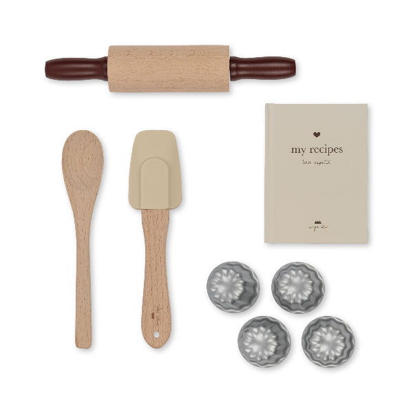 Child-sized baking equipment with rolling pin, mixing spoons and my recipes book perfect for little chefs
