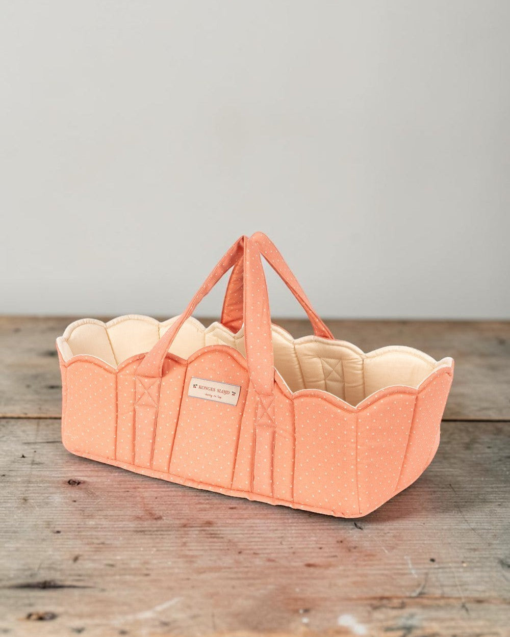 Playroom Collective Konges Sloejd quilted doll bassinet in coral with white dots and scalloped cream lining