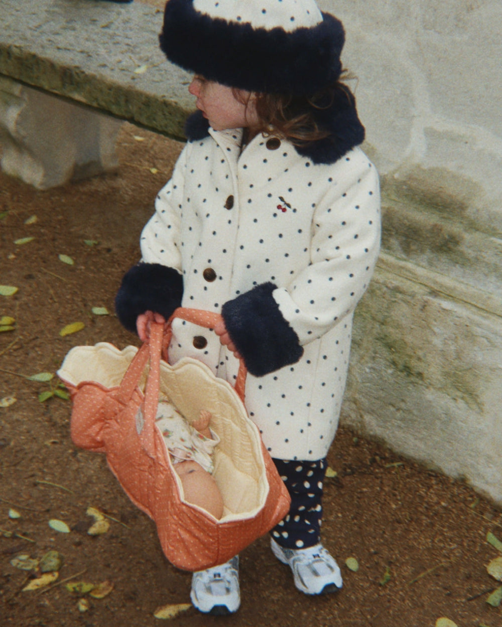 Child playing with Rose Dot Doll Bassinet