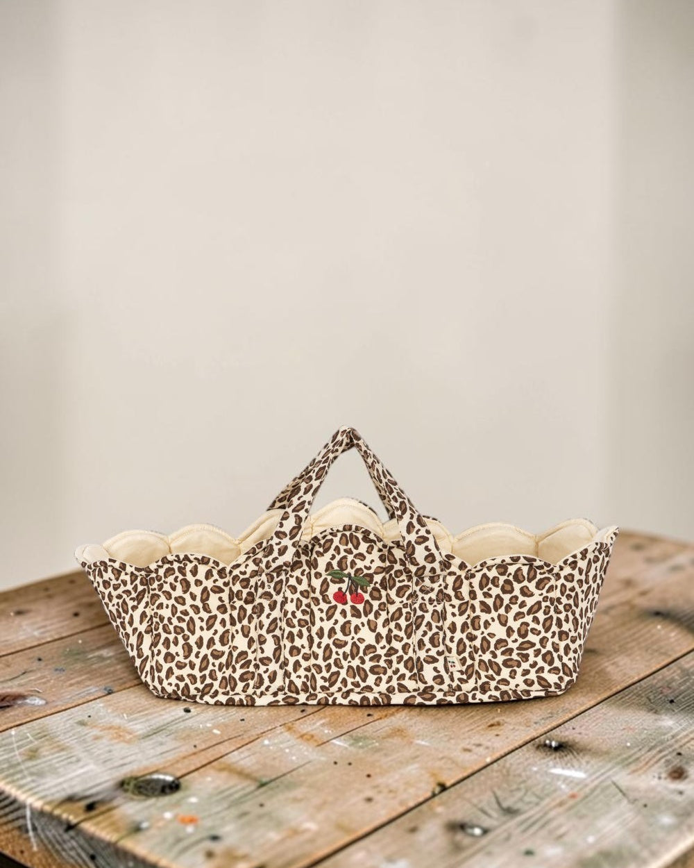 Playroom Collective quilted nursery storage basket in leopard print with scalloped edges and embroidered cherry detail