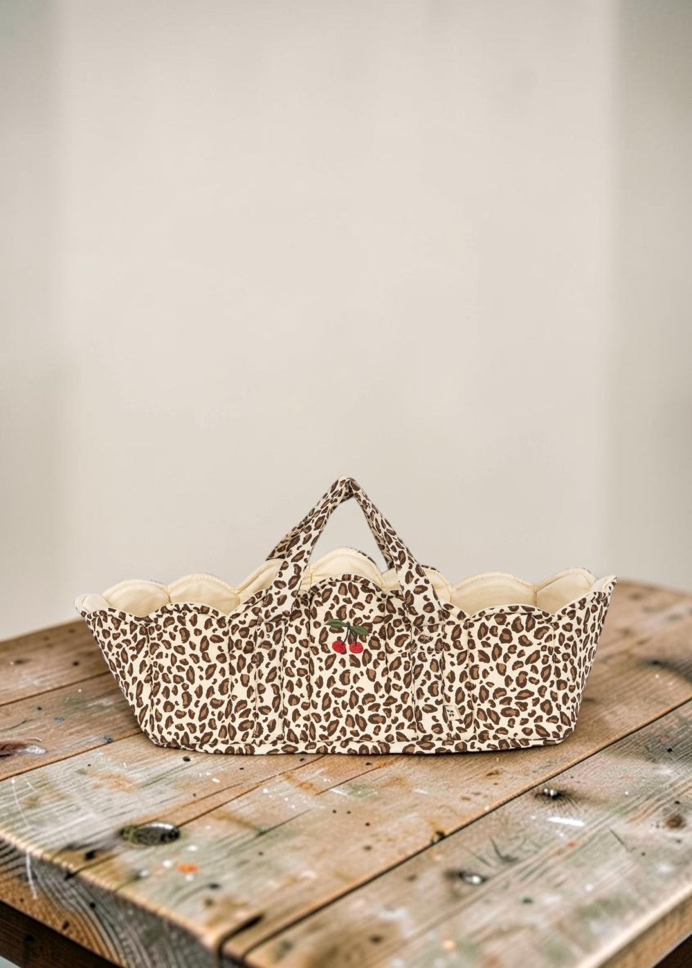 Playroom Collective quilted nursery storage basket in leopard print with scalloped edges and embroidered cherry detail