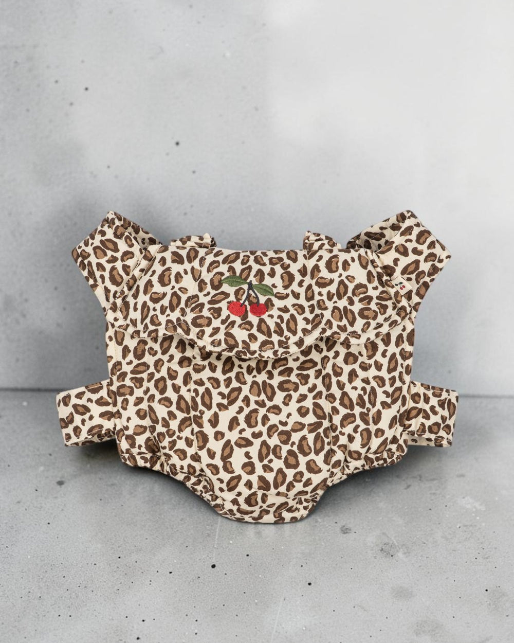 Playroom Collective Konges Sloejd leopard print doll carrier in cream and brown cotton with embroidered cherry detail.