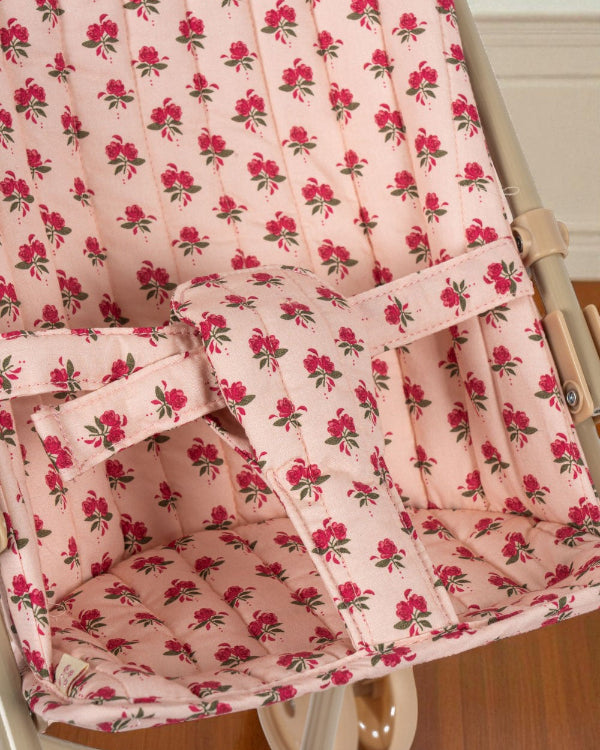 Secure fabric harness system in coordinating rose print ensuring safe doll positioning during stroller play